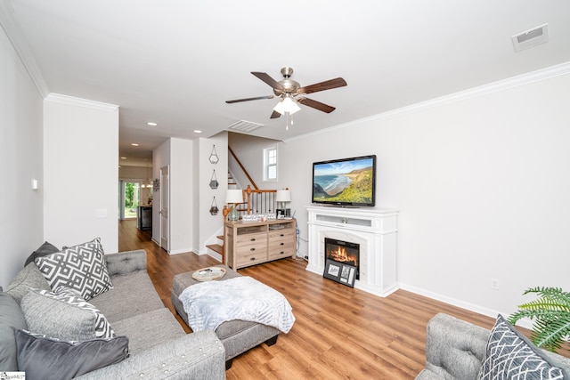 131 Highland Park Ct, Easley, SC 29642 - living room featuring stairs, ceiling fan, wood finished floors, crown molding, and a glass covered fireplace