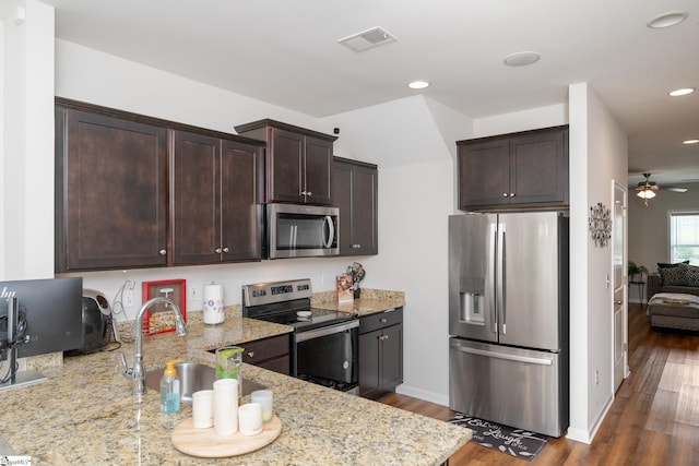 131 Highland Park Ct, Easley, SC 29642 - kitchen with appliances with stainless steel finishes, dark brown cabinetry, light stone counters, a ceiling fan, and wood finished floors