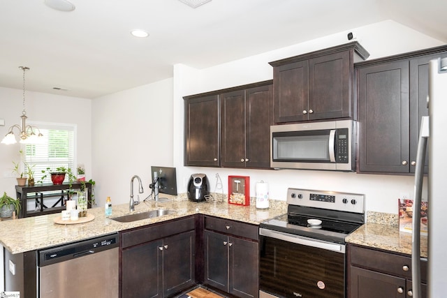 131 Highland Park Ct, Easley, SC 29642 - kitchen featuring appliances with stainless steel finishes, a peninsula, dark brown cabinetry, light stone counters, and decorative light fixtures