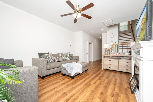 131 Highland Park Ct, Easley, SC 29642 - living room with ceiling fan, light wood-style floors, stairs, ornamental molding, and a fireplace