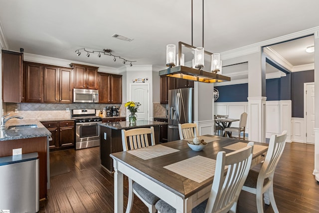 505 Jones Peak Dr, Simpsonville, SC 29681 - dining space with dark wood-style floors, ornamental molding, wainscoting, a decorative wall, and ornate columns