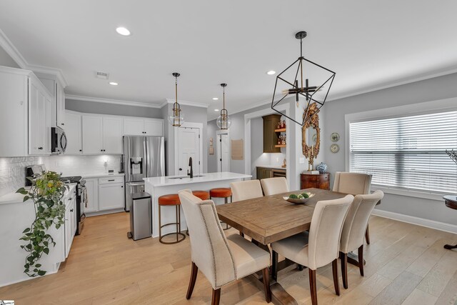 209 Pinckney St, Greenville, SC 29601 - dining area with light wood-style floors, a chandelier, ornamental molding, and recessed lighting