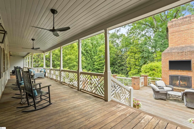 540 Crescent Ave, Greenville, SC 29601 - deck with an outdoor living space with a fireplace, ceiling fan, and view of wooded area