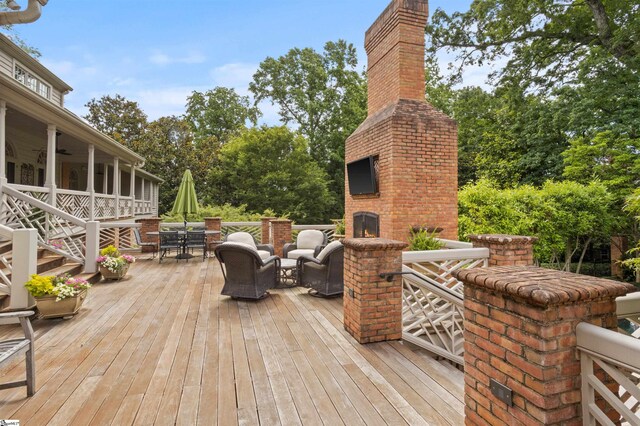 540 Crescent Ave, Greenville, SC 29601 - wooden terrace with an outdoor brick fireplace, outdoor dining space, view of wooded area, and ceiling fan