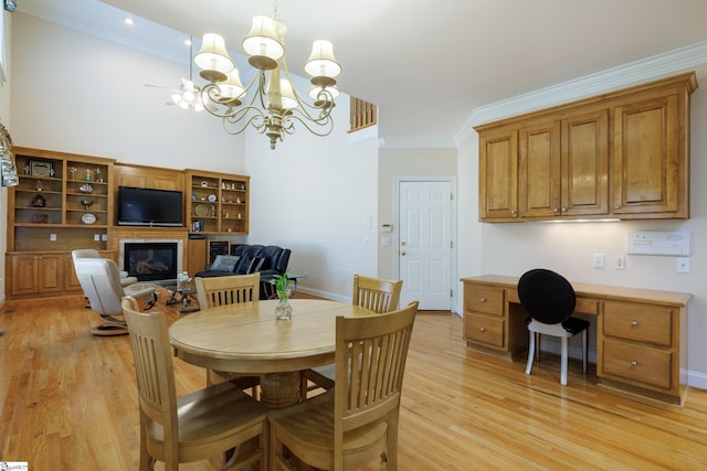 805 Carriage Hill Rd, Simpsonville, SC 29681 - dining area with light wood finished floors, ornamental molding, a chandelier, a glass covered fireplace, and built in study area