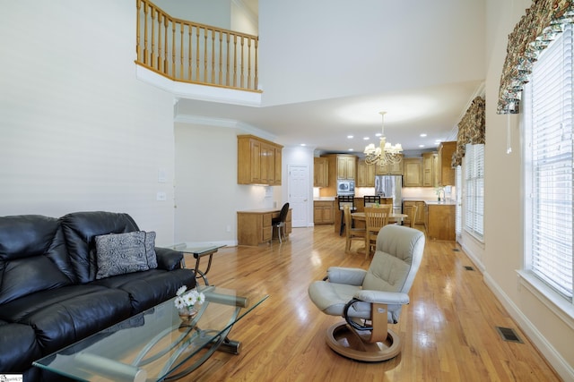 805 Carriage Hill Rd, Simpsonville, SC 29681 - living area featuring a chandelier, a high ceiling, light wood finished floors, crown molding, and recessed lighting