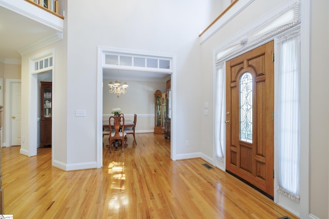 805 Carriage Hill Rd, Simpsonville, SC 29681 - entryway featuring ornamental molding, light wood finished floors, healthy amount of natural light, a chandelier, and a towering ceiling