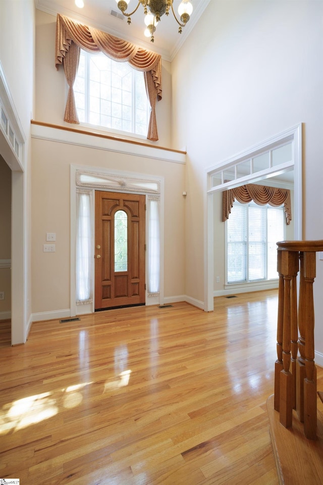 805 Carriage Hill Rd, Simpsonville, SC 29681 - foyer entrance featuring a high ceiling, a chandelier, light wood finished floors, and crown molding