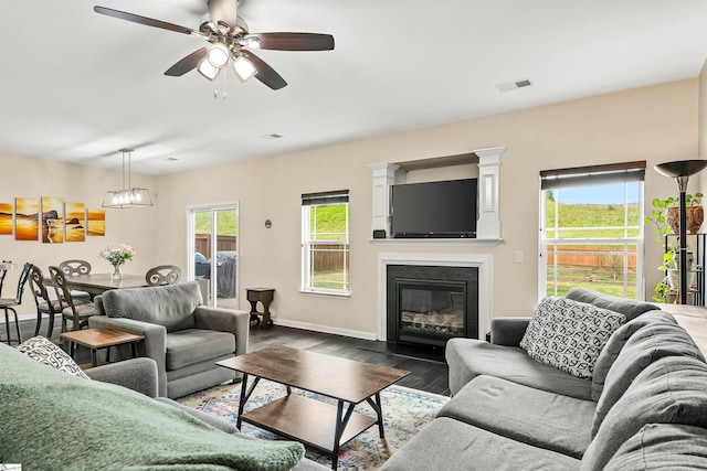 144 Caledonia Dr, Easley, SC 29642 - living area with dark wood-style floors, ceiling fan, and a fireplace with flush hearth