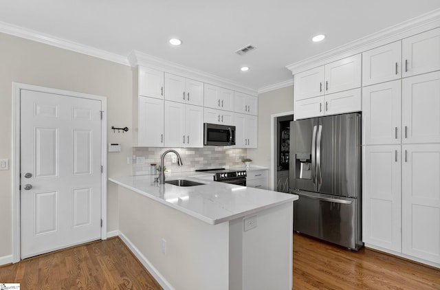 3 Promontory Ct, Greenville, SC 29615 - kitchen featuring appliances with stainless steel finishes, ornamental molding, white cabinetry, dark wood-style floors, and tasteful backsplash