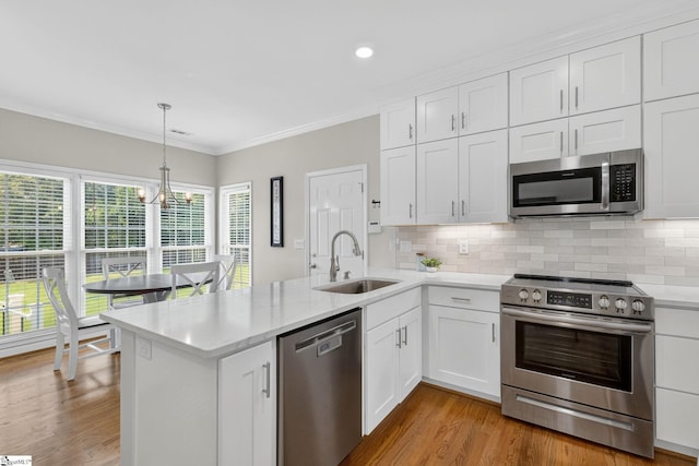 3 Promontory Ct, Greenville, SC 29615 - kitchen with appliances with stainless steel finishes, a peninsula, tasteful backsplash, white cabinetry, and ornamental molding