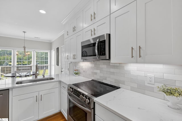 3 Promontory Ct, Greenville, SC 29615 - kitchen featuring stainless steel appliances, white cabinets, crown molding, backsplash, and light stone countertops
