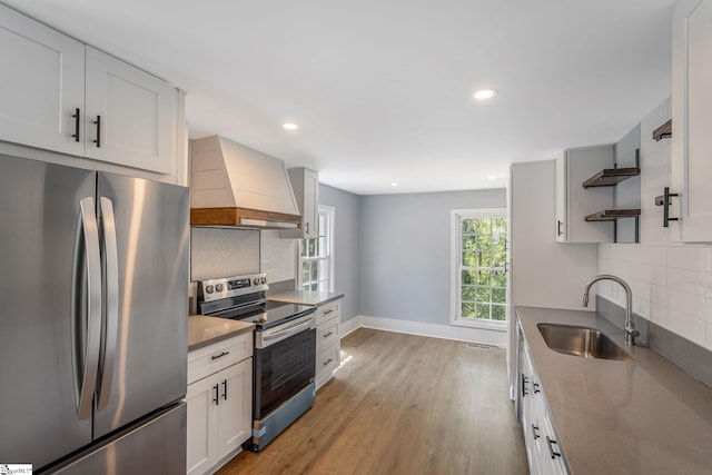 17 Allen St, Enoree, SC 29335 - kitchen with stainless steel appliances, custom range hood, open shelves, backsplash, and light wood-style floors