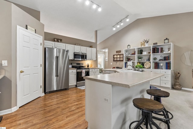 243 Rivers Edge Dr, Easley, SC 29642 - kitchen with appliances with stainless steel finishes, a breakfast bar, track lighting, lofted ceiling, and light countertops