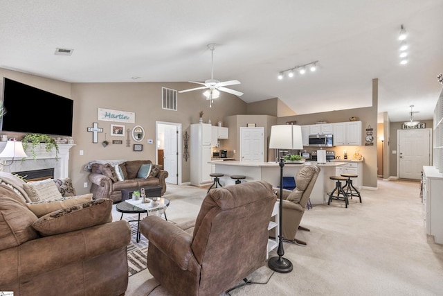 243 Rivers Edge Dr, Easley, SC 29642 - living area with light carpet, vaulted ceiling, ceiling fan, a high end fireplace, and rail lighting
