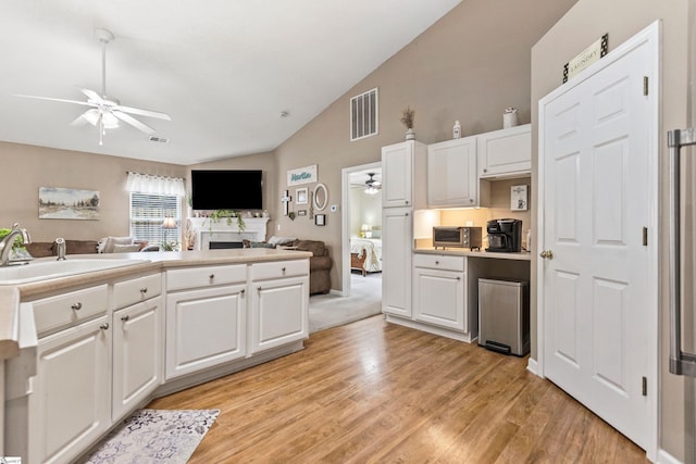 243 Rivers Edge Dr, Easley, SC 29642 - kitchen with ceiling fan, light wood-type flooring, white cabinets, a fireplace, and high vaulted ceiling