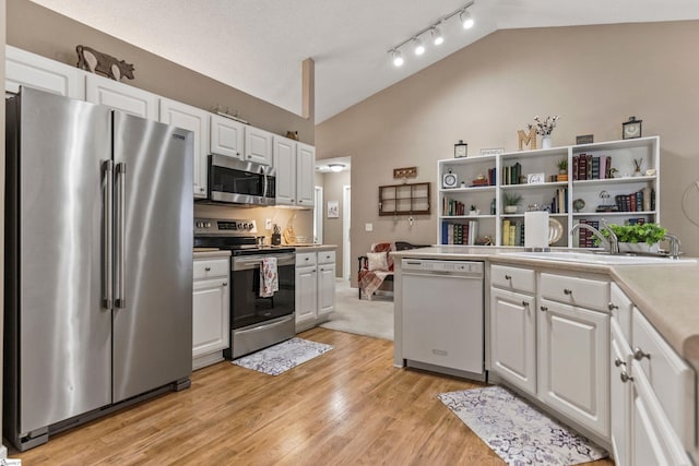 243 Rivers Edge Dr, Easley, SC 29642 - kitchen with stainless steel appliances, vaulted ceiling, open shelves, white cabinetry, and light countertops