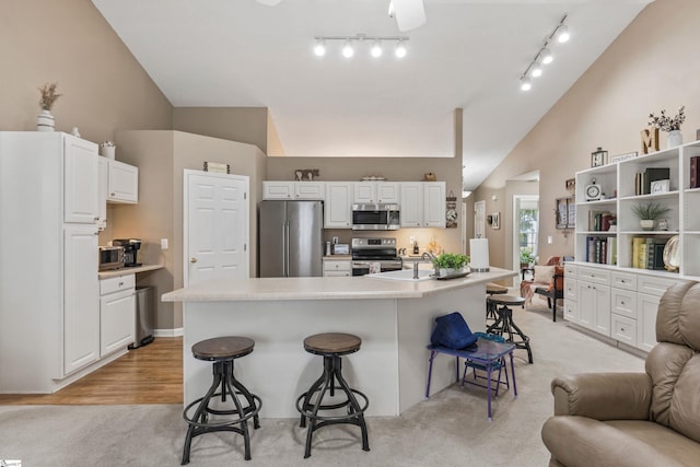 243 Rivers Edge Dr, Easley, SC 29642 - kitchen with appliances with stainless steel finishes, a breakfast bar area, lofted ceiling, white cabinetry, and open floor plan