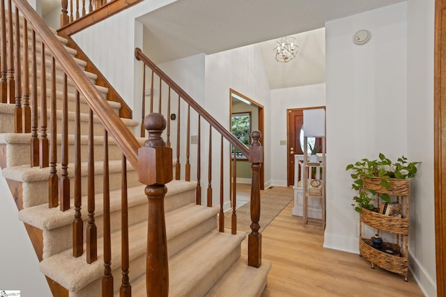 105 Fox Chase Ct, Simpsonville, SC 29680 - stairs featuring wood finished floors, a chandelier, and vaulted ceiling