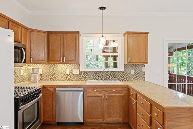 629 Germander Ct, Greer, SC 29651 - kitchen featuring stainless steel appliances, a peninsula, ornamental molding, tasteful backsplash, and brown cabinetry