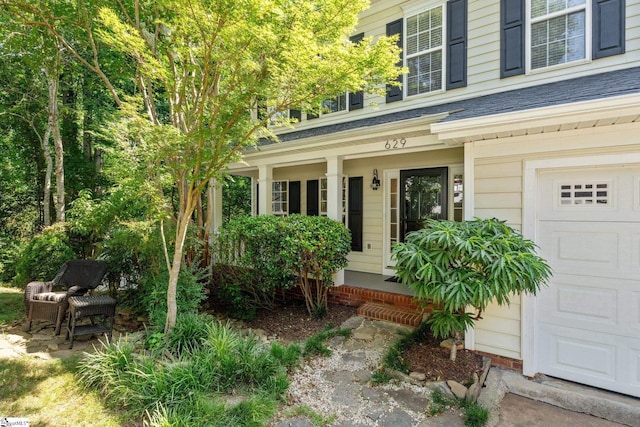 629 Germander Ct, Greer, SC 29651 - view of exterior entry with a porch, a garage, and a shingled roof