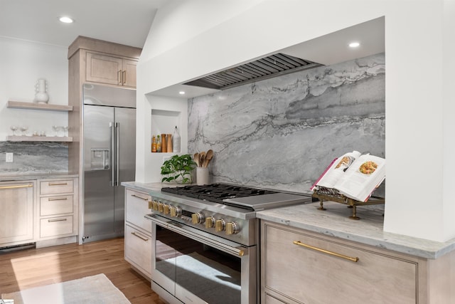 304 Waterford Fall Way, Simpsonville, SC 29681 - kitchen featuring premium appliances, light stone countertops, light wood-type flooring, light brown cabinets, and recessed lighting