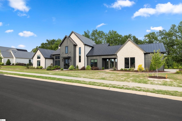 304 Waterford Fall Way, Simpsonville, SC 29681 - modern farmhouse with a standing seam roof, a metal roof, a front yard, and board and batten siding