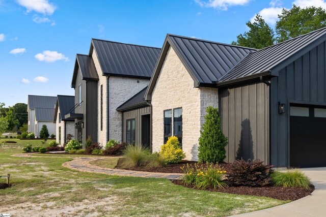 304 Waterford Fall Way, Simpsonville, SC 29681 - view of side of property featuring a standing seam roof, board and batten siding, stone siding, and a metal roof