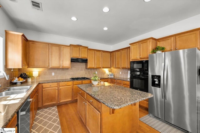 9 Springhead Way, Greer, SC 29650 - kitchen featuring black appliances, a kitchen island, light wood-type flooring, decorative backsplash, and recessed lighting