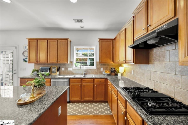 9 Springhead Way, Greer, SC 29650 - kitchen with under cabinet range hood, black gas cooktop, stainless steel dishwasher, light wood finished floors, and decorative backsplash