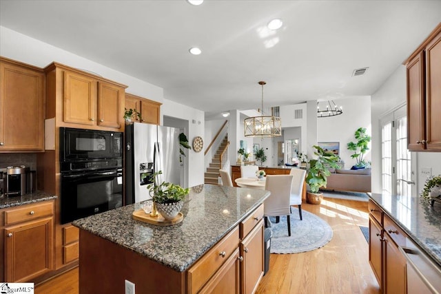 9 Springhead Way, Greer, SC 29650 - kitchen featuring black appliances, a chandelier, light wood-type flooring, a center island, and brown cabinets