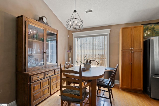 17 Lantern Ln, Greer, SC 29651 - dining space with light wood-style flooring, lofted ceiling, a chandelier, and a textured ceiling
