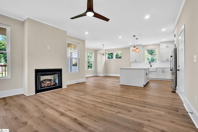 104 Ansel Dr, Clinton, SC 29325 - unfurnished living room featuring crown molding, a chandelier, a fireplace, light wood-style floors, and recessed lighting