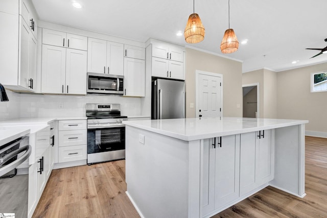 104 Ansel Dr, Clinton, SC 29325 - kitchen with appliances with stainless steel finishes, light wood finished floors, recessed lighting, a center island, and decorative backsplash