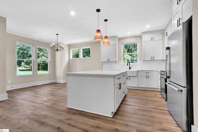 104 Ansel Dr, Clinton, SC 29325 - kitchen with appliances with stainless steel finishes, a chandelier, crown molding, light countertops, and decorative backsplash