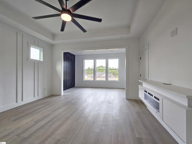 162 Refuge Church Rd, Central, SC 29630 - unfurnished living room featuring a tray ceiling, a ceiling fan, healthy amount of natural light, and light wood-type flooring