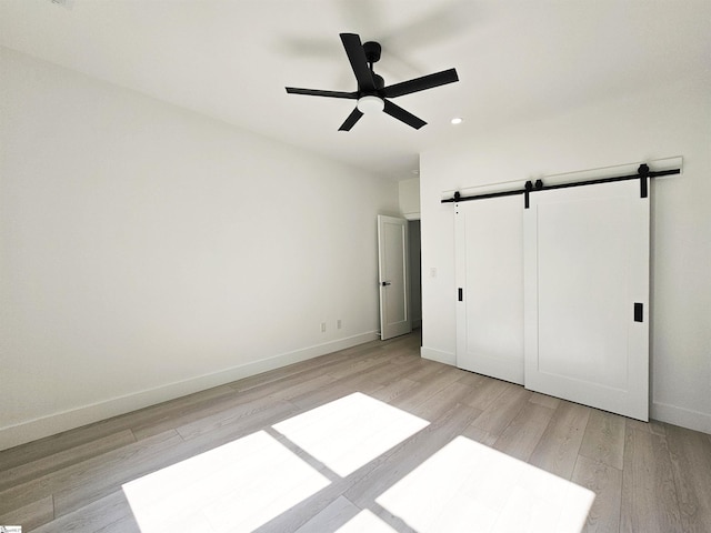 162 Refuge Church Rd, Central, SC 29630 - unfurnished bedroom featuring a barn door, light wood-type flooring, recessed lighting, and a ceiling fan