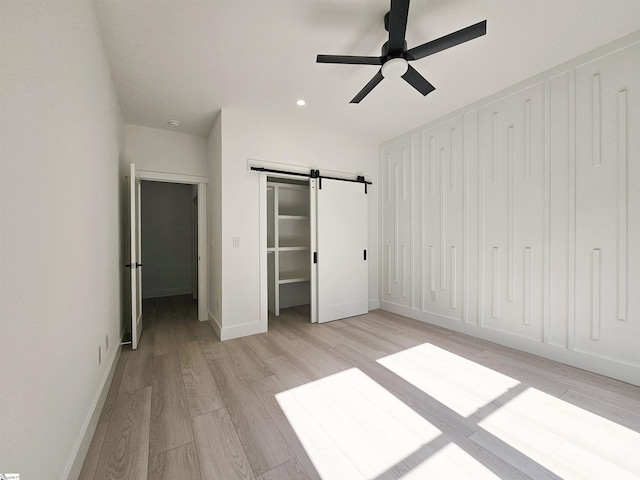 162 Refuge Church Rd, Central, SC 29630 - unfurnished bedroom with light wood-style floors, a barn door, recessed lighting, and a ceiling fan