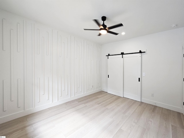 162 Refuge Church Rd, Central, SC 29630 - unfurnished bedroom with a barn door, light wood-type flooring, and a ceiling fan