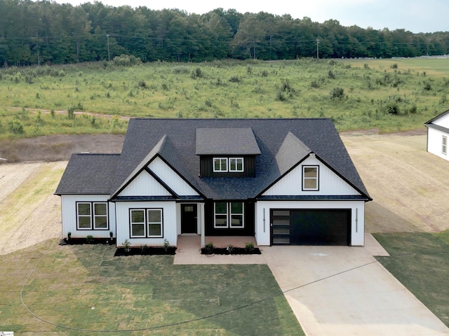 2927 Old Greenville Hwy, Central, SC 29630 - modern inspired farmhouse with concrete driveway, roof with shingles, a forest view, and an attached garage