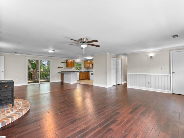 113 Commodore Dr, Duncan, SC 29334 - living room with a wood stove, a ceiling fan, hardwood / wood-style floors, ornamental molding, and wainscoting