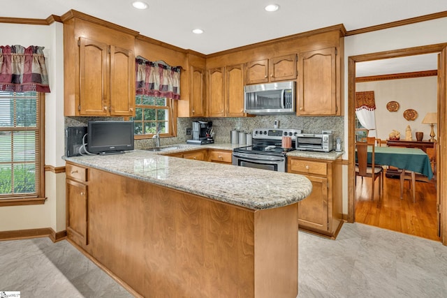 102 Linwood Ct, Simpsonville, SC 29681 - kitchen with appliances with stainless steel finishes, crown molding, a peninsula, decorative backsplash, and brown cabinets