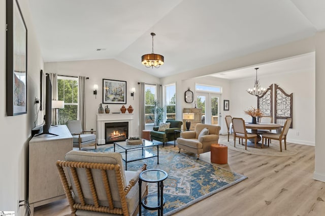 240 Nicole Marie Ct, Greer, SC 29651 - living area with a chandelier, vaulted ceiling, healthy amount of natural light, light wood-style floors, and a glass covered fireplace