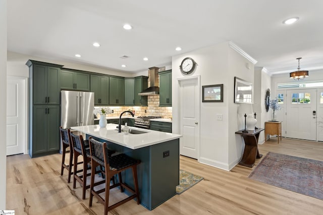 240 Nicole Marie Ct, Greer, SC 29651 - kitchen with green cabinetry, stainless steel appliances, wall chimney exhaust hood, light wood-style flooring, and a kitchen bar