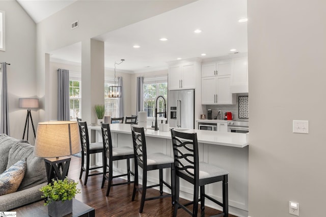 6 Nakkol Dr, Simpsonville, SC 29680 - kitchen with high end refrigerator, a breakfast bar, light countertops, a chandelier, and white cabinetry