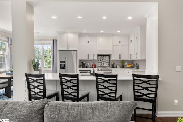 6 Nakkol Dr, Simpsonville, SC 29680 - kitchen featuring high end refrigerator, a kitchen bar, backsplash, white cabinetry, and healthy amount of natural light
