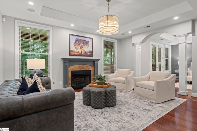 19 Hobcaw Dr, Greer, SC 29650 - living room with decorative columns, dark wood finished floors, a raised ceiling, arched walkways, and a fireplace