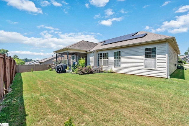 201 Evansdale Way, Simpsonville, SC 29680 - back of house with roof mounted solar panels, a fenced backyard, and roof with shingles