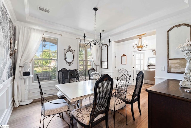 201 Evansdale Way, Simpsonville, SC 29680 - dining space with a chandelier, crown molding, light wood-type flooring, and a decorative wall