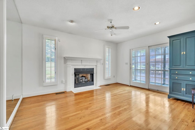 19 E Circle Ave, Greenville, SC 29607 - unfurnished living room with a ceiling fan, light wood finished floors, a fireplace with flush hearth, recessed lighting, and a textured ceiling